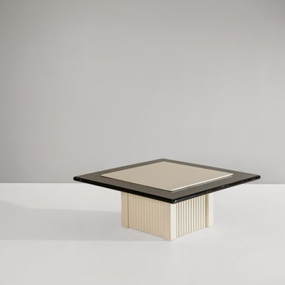 a black and white table with a square glass top on a white surface