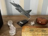 a table with a book, a clock, and a toy airplane on it