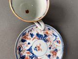 two cups and saucers are sitting side by side on a table