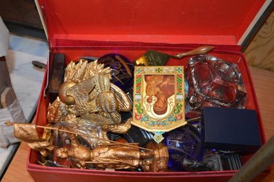 une boîte rouge remplie d'objets divers, posée sur une table