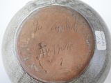 a brown vase with writing on it sitting on a table