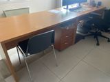 a desk with a computer and a chair in the room