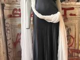 a mannequin dressed in a black dress and white scarf
