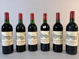 six bouteilles de vin rouge sont alignées sur une table