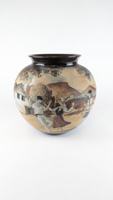 a vase with a painting on it sitting on a table