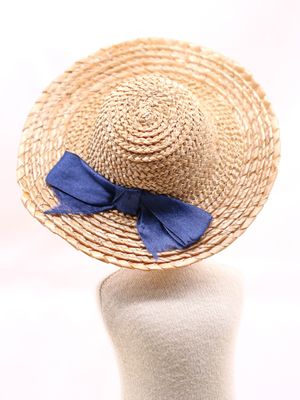 un chapeau de paille orné d'un nœud bleu sur le dessus