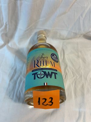 une bouteille de liquide posée sur un drap blanc, avec une étiquette de prix