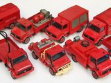 beaucoup de petits camions rouges en plastique posés sur la table
