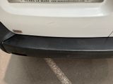 the back end of a white car with a license plate on it