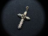 a close up of a silver cross on a black background