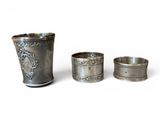 three silver cups with designs on them sitting next to each other