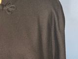 the back of a black dress with a bow tie on it