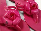 pair of pink flip flops with a flower on the toe
