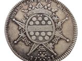 an old silver coin with a coat of arms and a cross on it