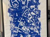 framed blue and white abstract painting on a wall in a living room
