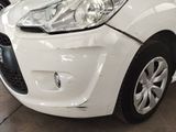 a close up of a white car that has been dented
