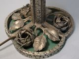 a silver vase with a flower on it on a table