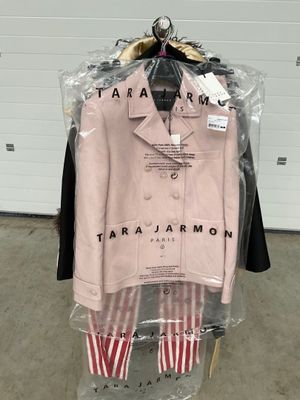 une veste et un pantalon roses suspendus à un cintre dans un magasin