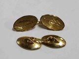 une paire de boutons de manchette dorés et une paire de boutons de manchette dorés