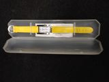 a yellow watch in a clear case on a black surface