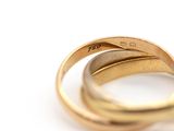 a close up of two gold rings on a white surface
