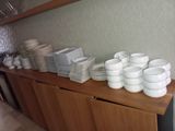 a lot of plates and cups on a wooden shelf