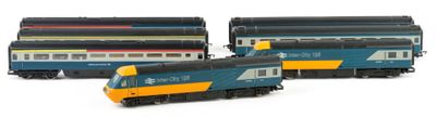 three model trains sitting next to each other on a white surface