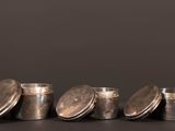 Quatre récipients métalliques sont alignés sur une table
