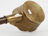 an old brass pipe with a wooden handle on a white surface