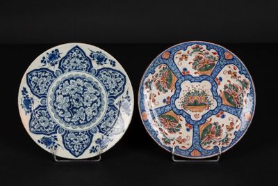 two blue and white plates with floral designs on them on a black surface