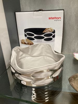 un sac blanc posé sur une table en verre, à côté d'un bol