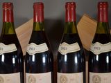 four bottles of wine are lined up in a row on a table