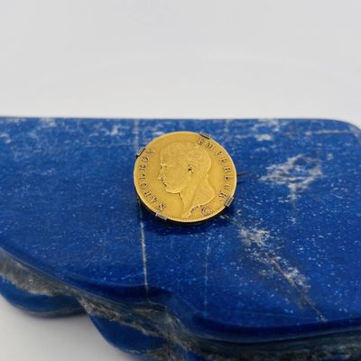 a gold coin sitting on top of a piece of blue marble