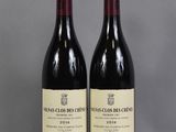 two bottles of wine sitting on top of a table next to each other