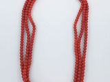 un gros plan sur un collier rouge orné d'une rose