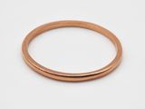 gros plan d'une bague en or sur une surface blanche