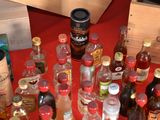 many bottles of alcohol on a table with a red table cloth