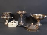 trois tasses en argent et une petite boîte posées sur une table