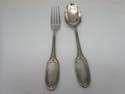 two spoons and a fork on a white table