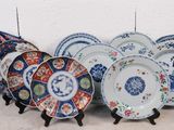 cinq assiettes posées sur un présentoir, chacune ornée d'un motif différent