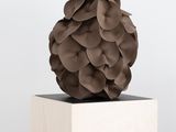 une sculpture représentant une balle posée sur une caisse en bois
