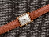 un gros plan d'une montre-bracelet avec un bracelet en cuir marron