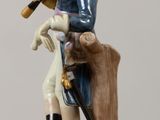 a figurine of a man sitting on a bench with a dog