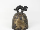 an old bell with a bird on it sitting on a white surface