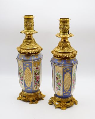 une paire de vases bleus et dorés ornés de fleurs sur fond blanc