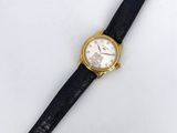 a close up of a watch on a white surface with a black strap
