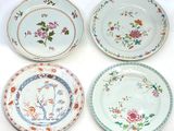 quatre assiettes ornées de motifs floraux, posées sur une surface blanche