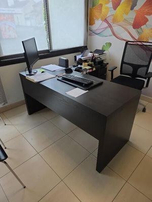 un bureau avec un ordinateur et une chaise dans une pièce