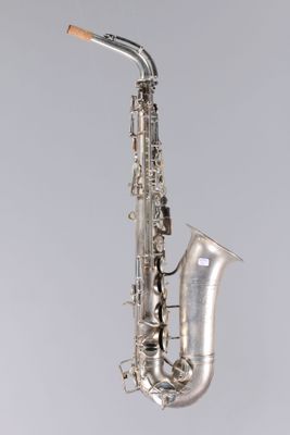 un gros plan d'un saxophone sur fond gris