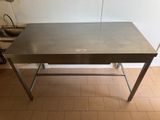 une table en acier inoxydable dans une cuisine au sol carrelé